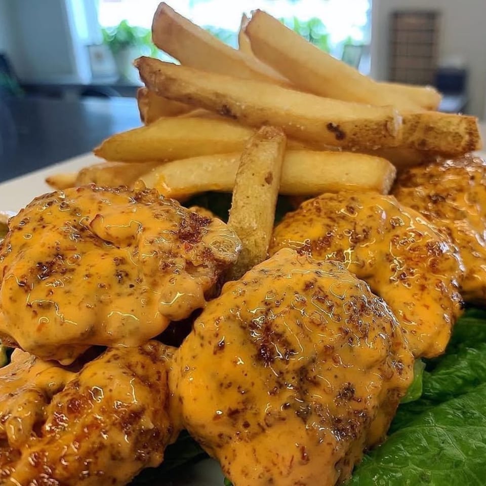 Brynn Bradley's cheesesteak bites with a creamy sauce, served with golden french fries on a bed of lettuce.